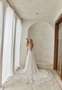 Cher - Stella's Bridal An a-line wedding dress in chiffon, featuring 3D florals and illusion side cut-outs. Shown in Ivory and designed by Serene by Madi Lane Bridal. A modern bridal gown available at Stella’s Bridal in Westminster, Maryland. Serene by Madi Lane Bridal Style SR2605 Cher.