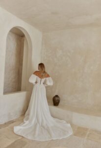 Sam - Stella's Bridal An a-line wedding dress in patterned chiffon, featuring a basque waistline and optional sleeves. Shown in Ivory and designed by Serene by Madi Lane Bridal. A modern bridal gown available at Stella’s Bridal in Westminster, Maryland. Serene by Madi Lane Bridal Style SR2616 Sam.