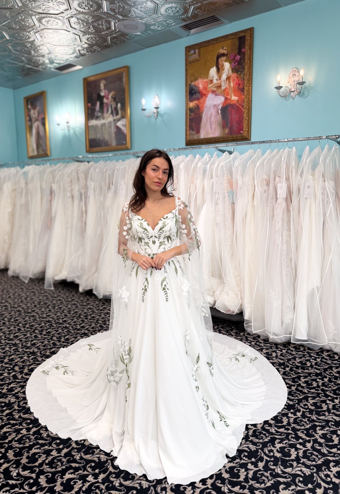 Bishop Bloom - Stella's Bridal An a-line wedding dress in chiffon, featuring floral lace and spaghetti straps. Shown in Green floraly and Ivory and designed by Stella's Collection. A modern bridal gown available at Stella’s Bridal in Westminster, Maryland.