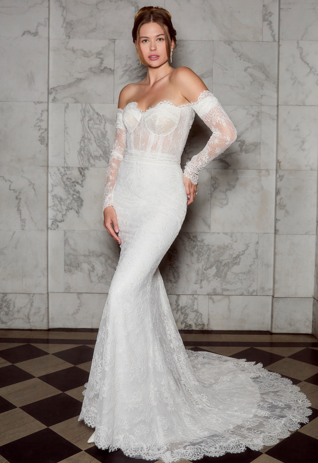 Cosette - Stella's Bridal A fitted wedding dress in lace, featuring a scalloped lace train and optional sleeves. Shown in Ivory and designed by Casablanca Bridal. A modern bridal gown available at Stella’s Bridal in Westminster, Maryland. Casablanca Bridal Style 2580 Cosette, inspired by Hailey Bieber's Wedding Dress.