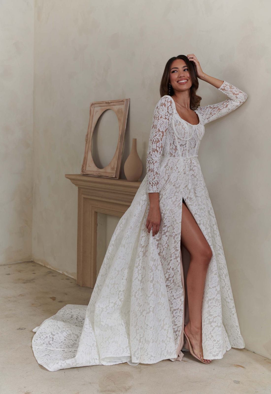 Bellamy - Stella's Bridal An a-line wedding dress in lace, featuring a high slit, square neckline, and optional sleeves. Shown in Ivory/Nude and designed by Serene by Madi Lane Bridal. A modern bridal gown available at Stella’s Bridal in Westminster, Maryland. Serene by Madi Lane Bridal Style SR2433 Bellamy.