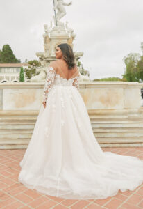 Esme - Stella's Bridal Stella York 8012 wedding dress featuring a ballgown silhouette with long sleeve illusion neckline, tulle skirt, and lace details. Available at Stella’s Bridal in Westminster, Maryland.
