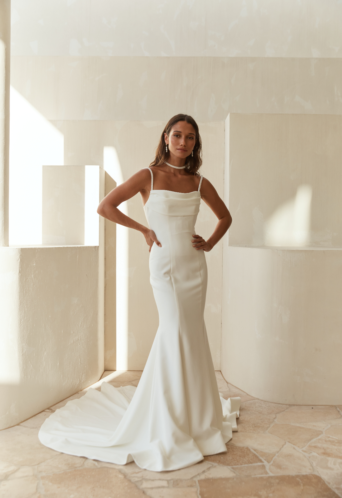 Novalis - Stella's Bridal Serene by Madi Lane Novalis wedding dress featuring a sheath silhouette with square neckline, crepe skirt, and beaded details. Available at Stella’s Bridal in Westminster, Maryland.