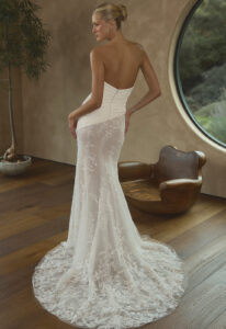 Ridley - Stella's Bridal Casablanca Ridely wedding dress featuring a fitted silhouette with straight neckline, asymmetrical lace skirt, and ruched crepe details. Available at Stella’s Bridal in Westminster, Maryland.