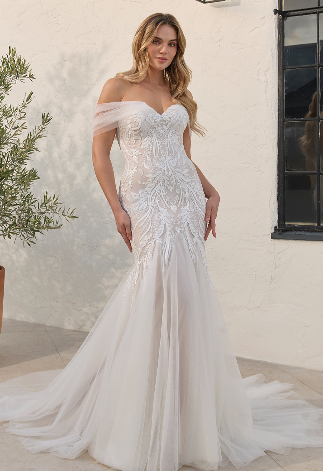 Wynn - Stella's Bridal Beloved by Casablanca Wynn wedding dress featuring a mermaid silhouette with sweetheart neckline, boho lace skirt, and cap sleeve details. Available at Stella’s Bridal in Westminster, Maryland.