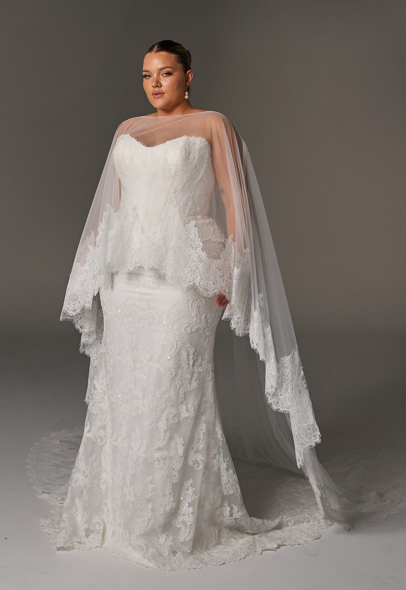 Evie Young Janet wedding dress featuring a fitted peplum silhouette with sweetheart neckline, lace skirt, and corseted details. Available at Stella’s Bridal in Westminster, Maryland.
