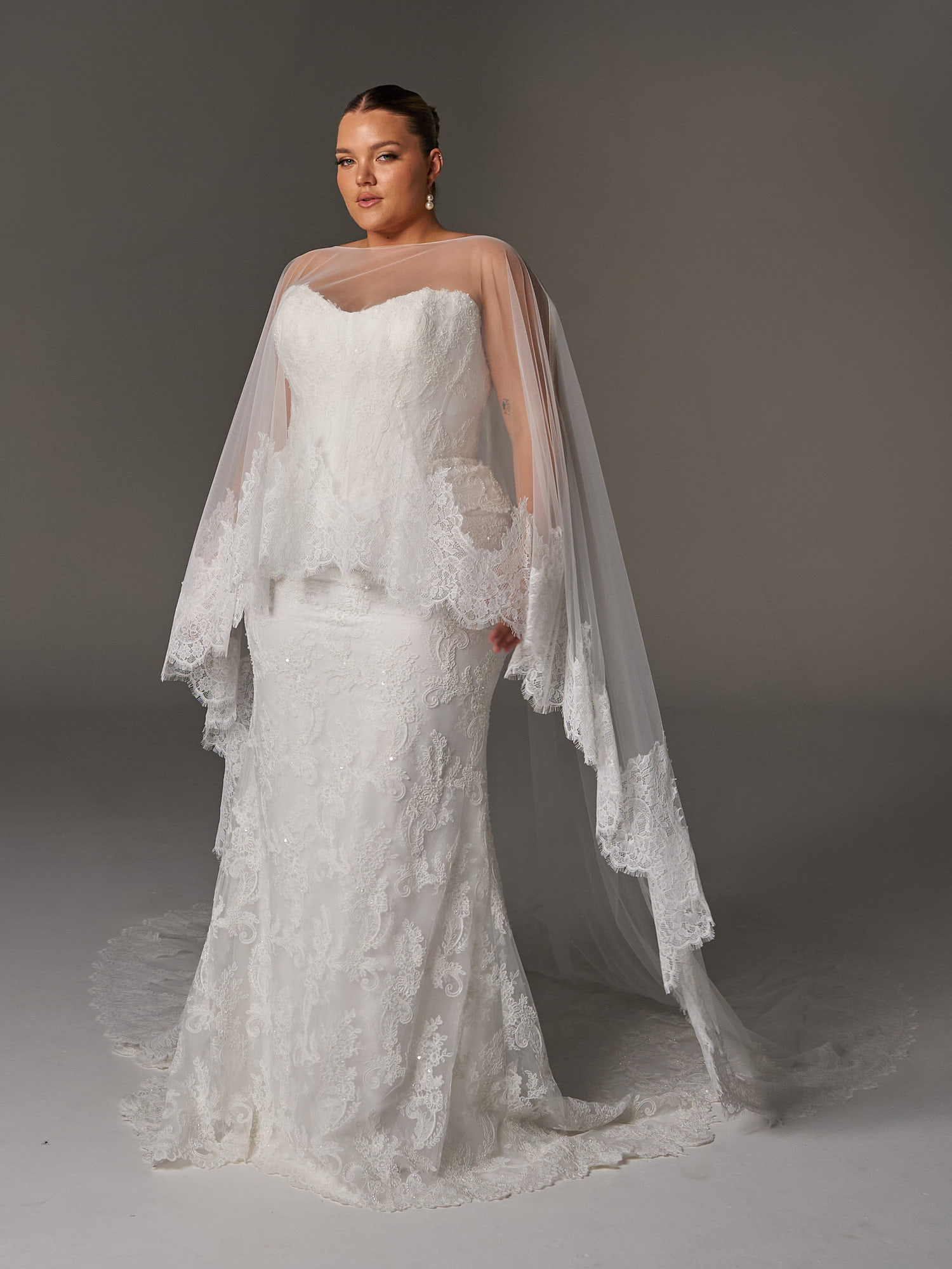 Evie Young Janet wedding dress featuring a fitted peplum silhouette with sweetheart neckline, lace skirt, and corseted details. Available at Stella’s Bridal in Westminster, Maryland.