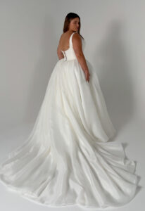 Mirage - Stella's Bridal Serene by Madi Lane Mirage wedding dress featuring a ballgown silhouette with square neckline, patterned organza skirt, and pleated details. Available at Stella’s Bridal in Westminster, Maryland.