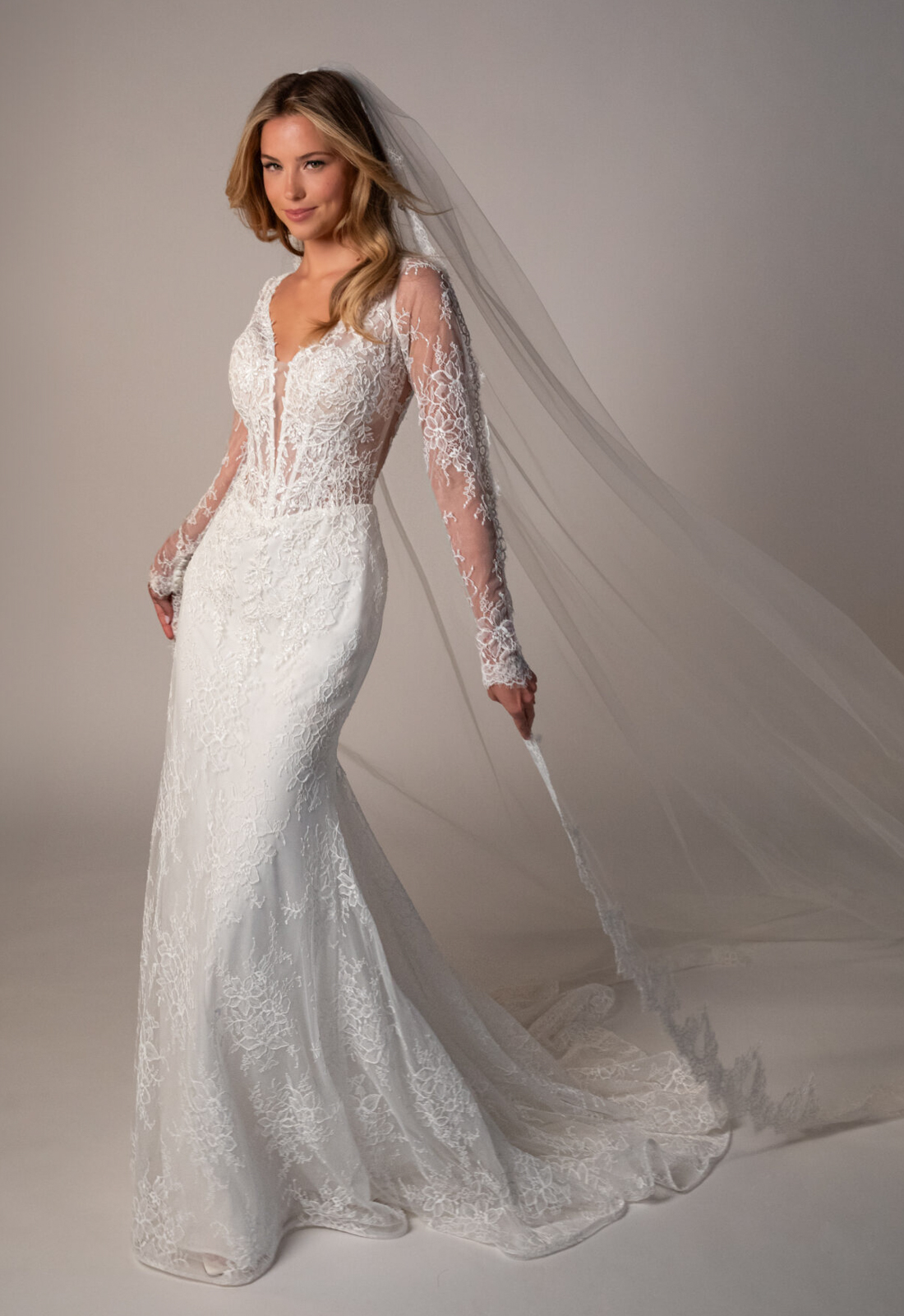 Stella York SY8305 Nyx wedding dress featuring a fitted silhouette, long sleeve plunging neckline, and chantilly lace fabric, shown from the front. Available at Love it at Stella's Bridal in Westminster, Maryland