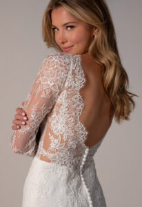 Stella York SY8305 Nyx wedding dress featuring a fitted silhouette, long sleeve plunging neckline, and chantilly lace fabric, showing a close up of the back. Available at Love it at Stella's Bridal in Westminster, Maryland